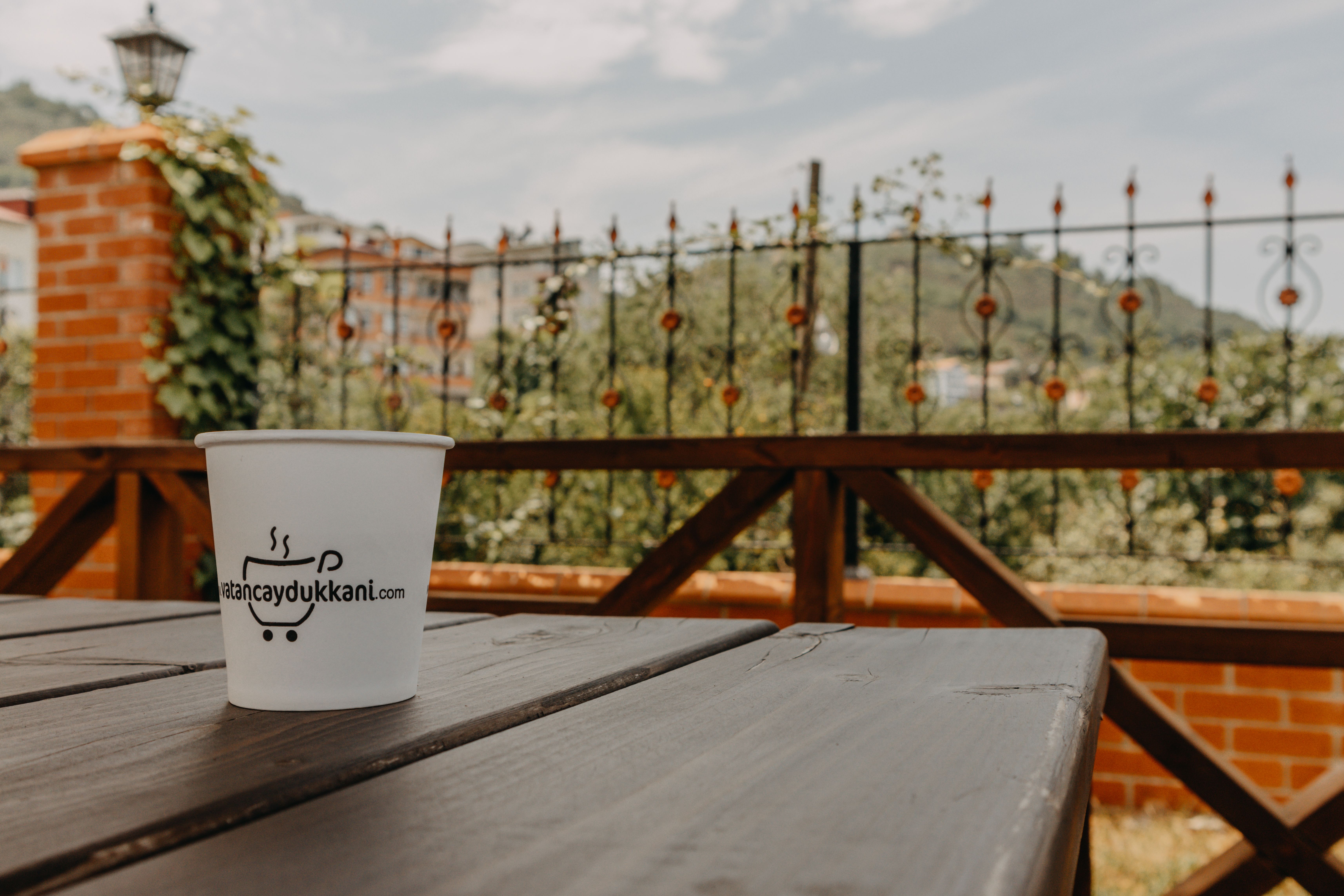 A sunset view from a hotel terrace in Ho, with a cup of tea on a wooden table