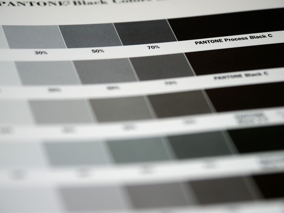 Printed color swatches and layout samples beside design tools