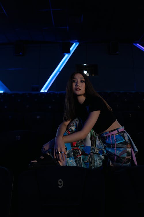 Photo of a Stylish Woman Posing in a Movie Theater