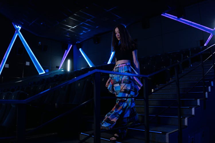 Woman Walking Down The Stairs In A Movie Theater