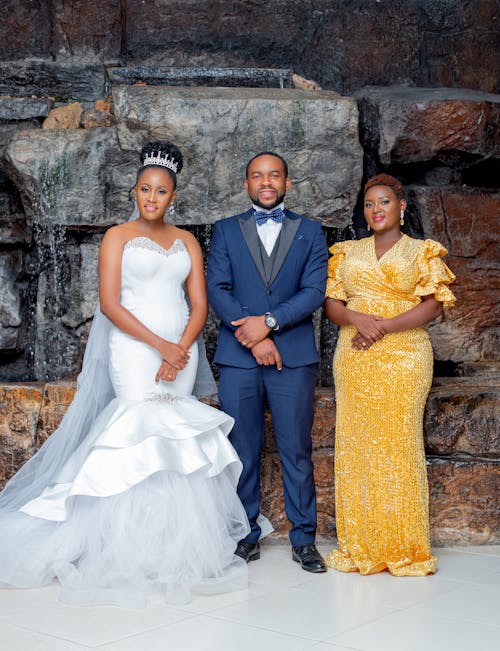 A Bride Beside a  Woman and Man Wearing Formal Attires