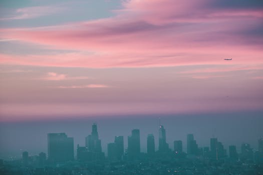 粉红色的日落下，美丽的城市景观与摩天大楼和飞机相映成趣