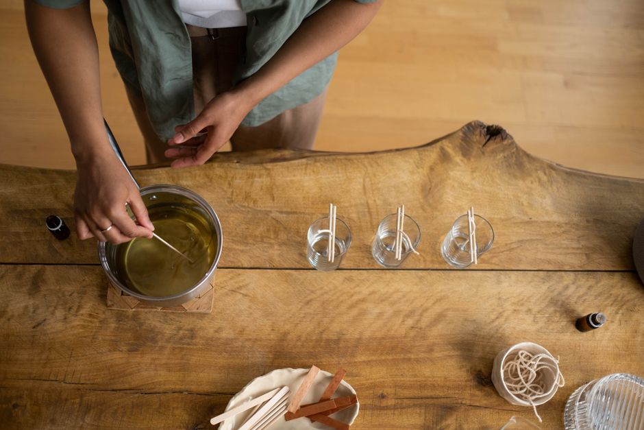 Variation 4 — overhead of a wax pot being stirred beside three wicked glasses — photo by Ron Lach on Pexels