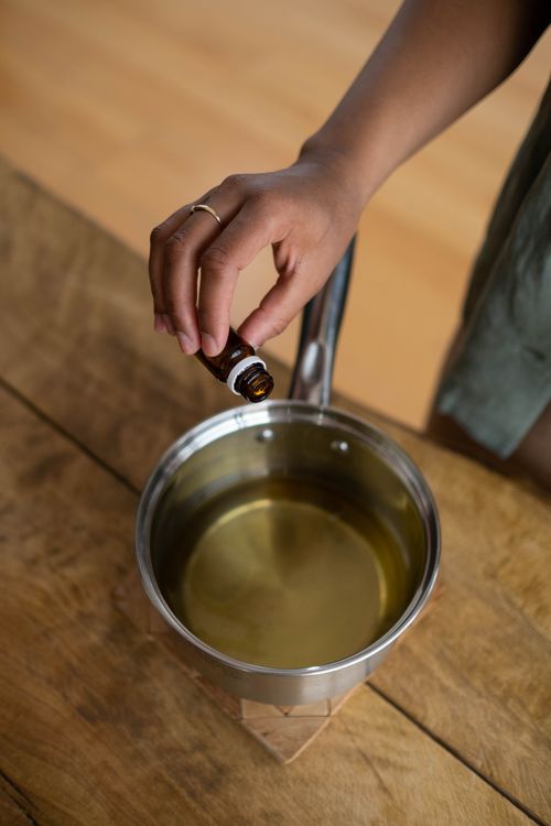 Free A person adding essential oil to candle wax for homemade aromatherapy candles. Stock Photo