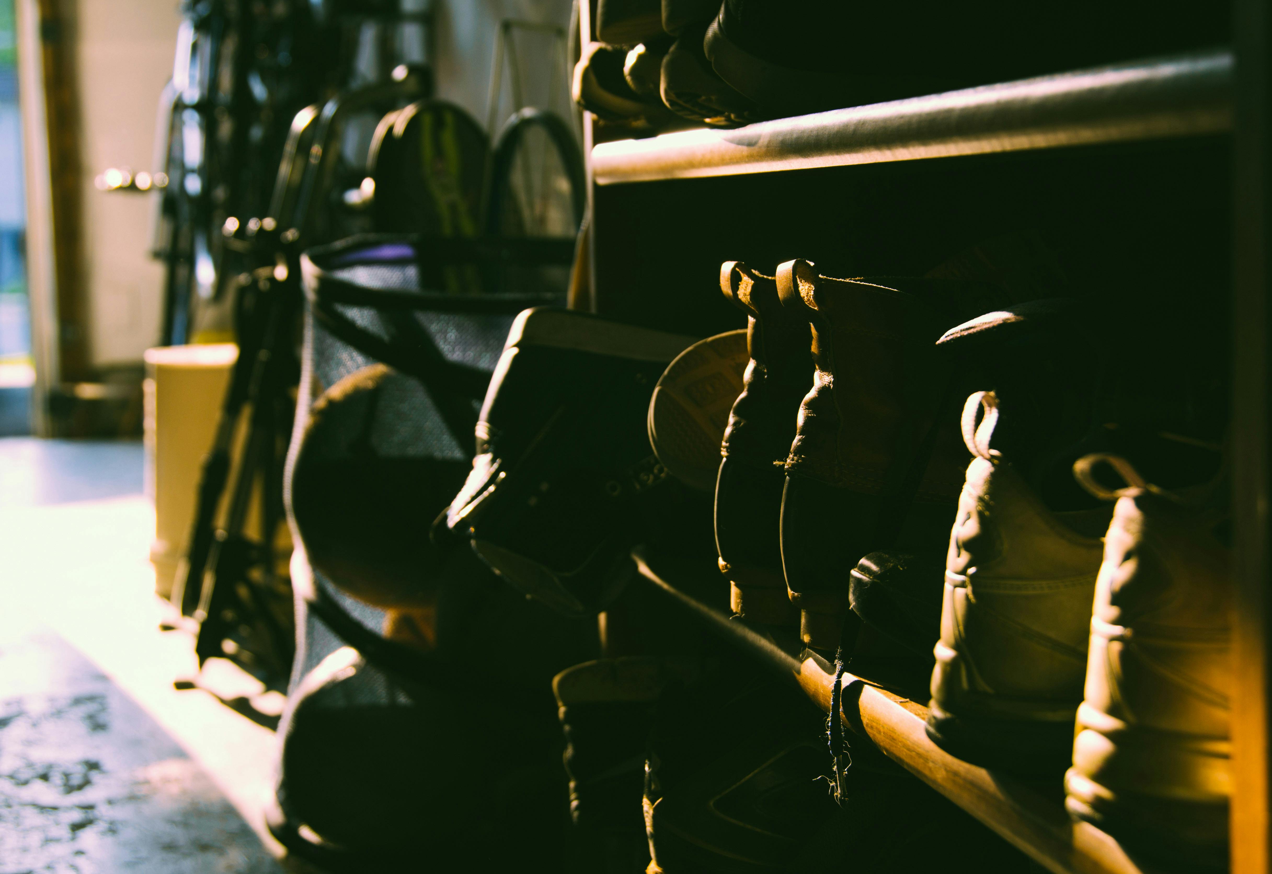 Black Work Boots On Brown Wooden Shoe Rack Free Stock Photo