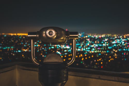 Black Binocular Facing Lighted City at Nighttime