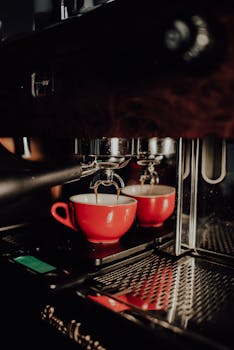 Capture of coffee brewing into a red cup using an espresso machine, highlighting perfect blend preparation.