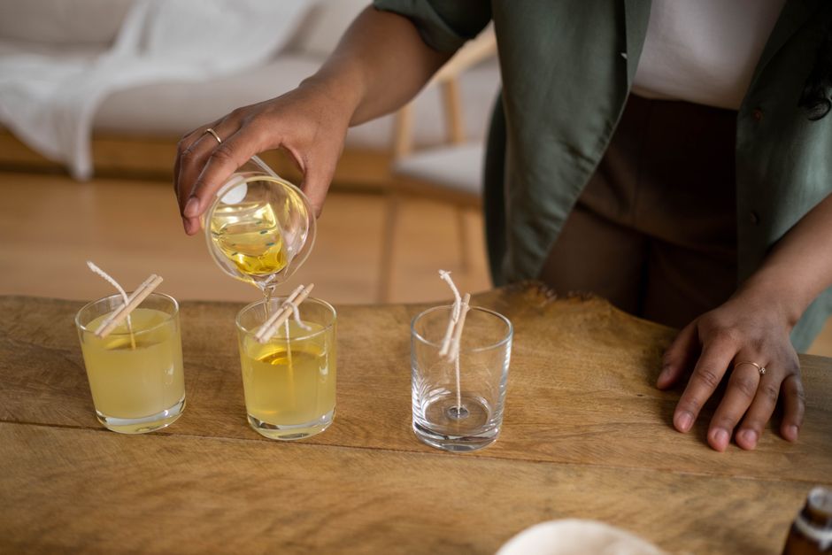 Golden wax poured into wicked glasses on a workbench — photo by Ron Lach on Pexels