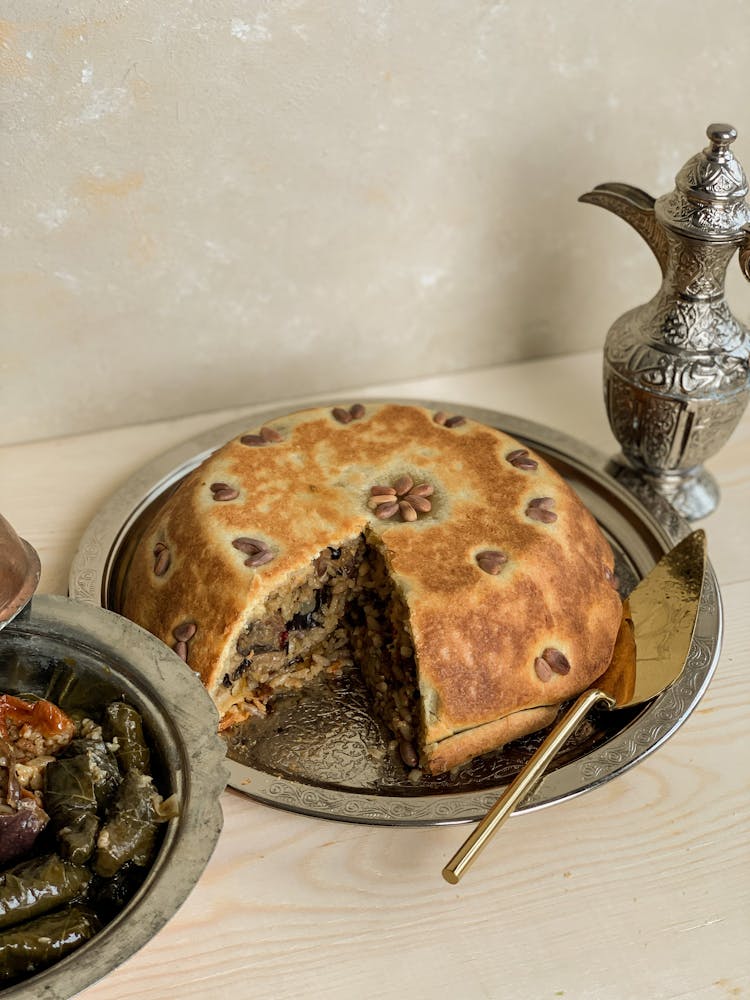 Cut Meat Pie On Metal Plate Near Jug