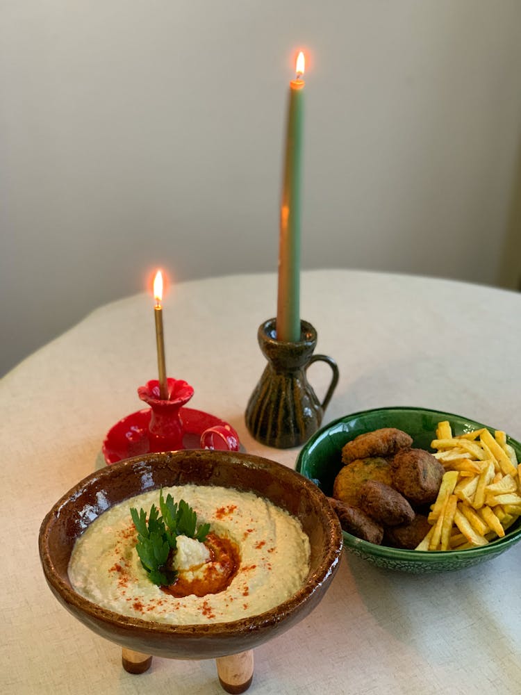 Vegetable Spread And Meatballs With French Fries Near Burning Candles