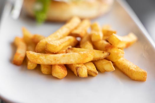 Close-up of crispy golden french fries served on a plate, perfect for finger food.