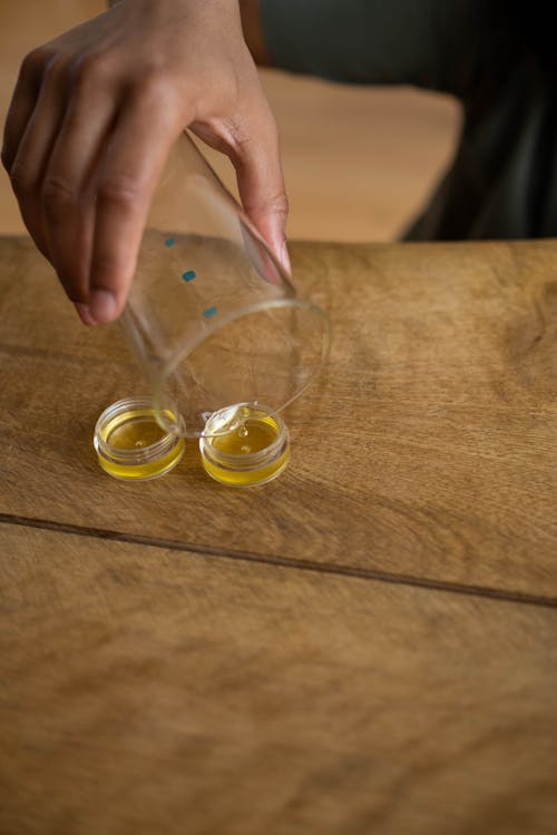 Close-up of Pouring Oil on Containers