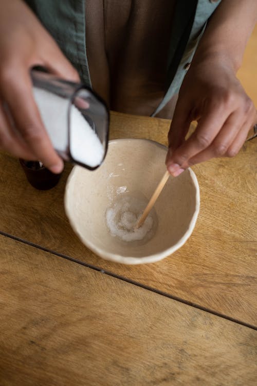 A Person Mixing the Sugar on the Bowl Using a Popsicle Stick