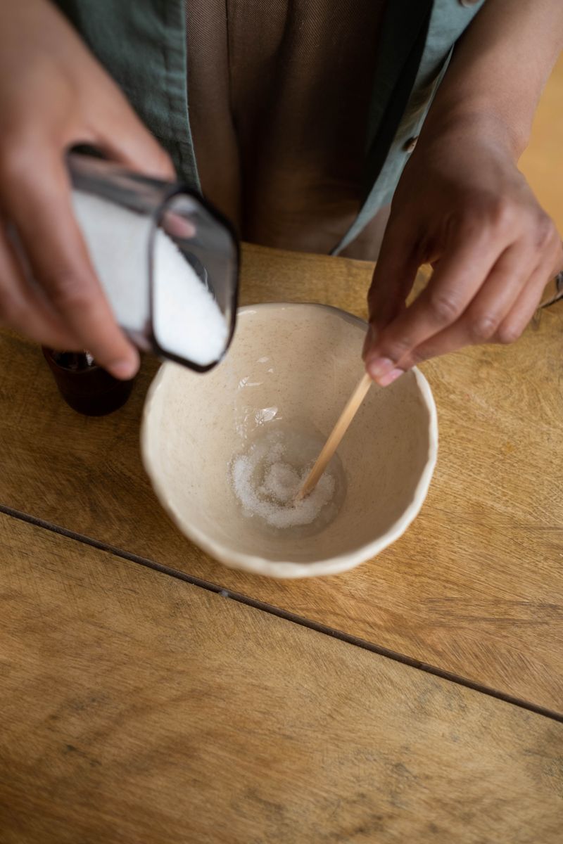 Close-up of hands mixing ingredients in a bowl for a DIY solution