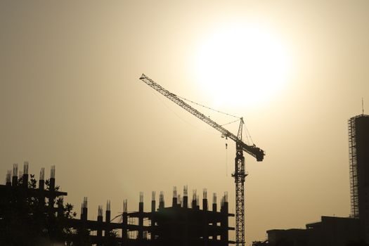 Silhouette of a construction crane during sunset at a building site in Tehran, Iran.