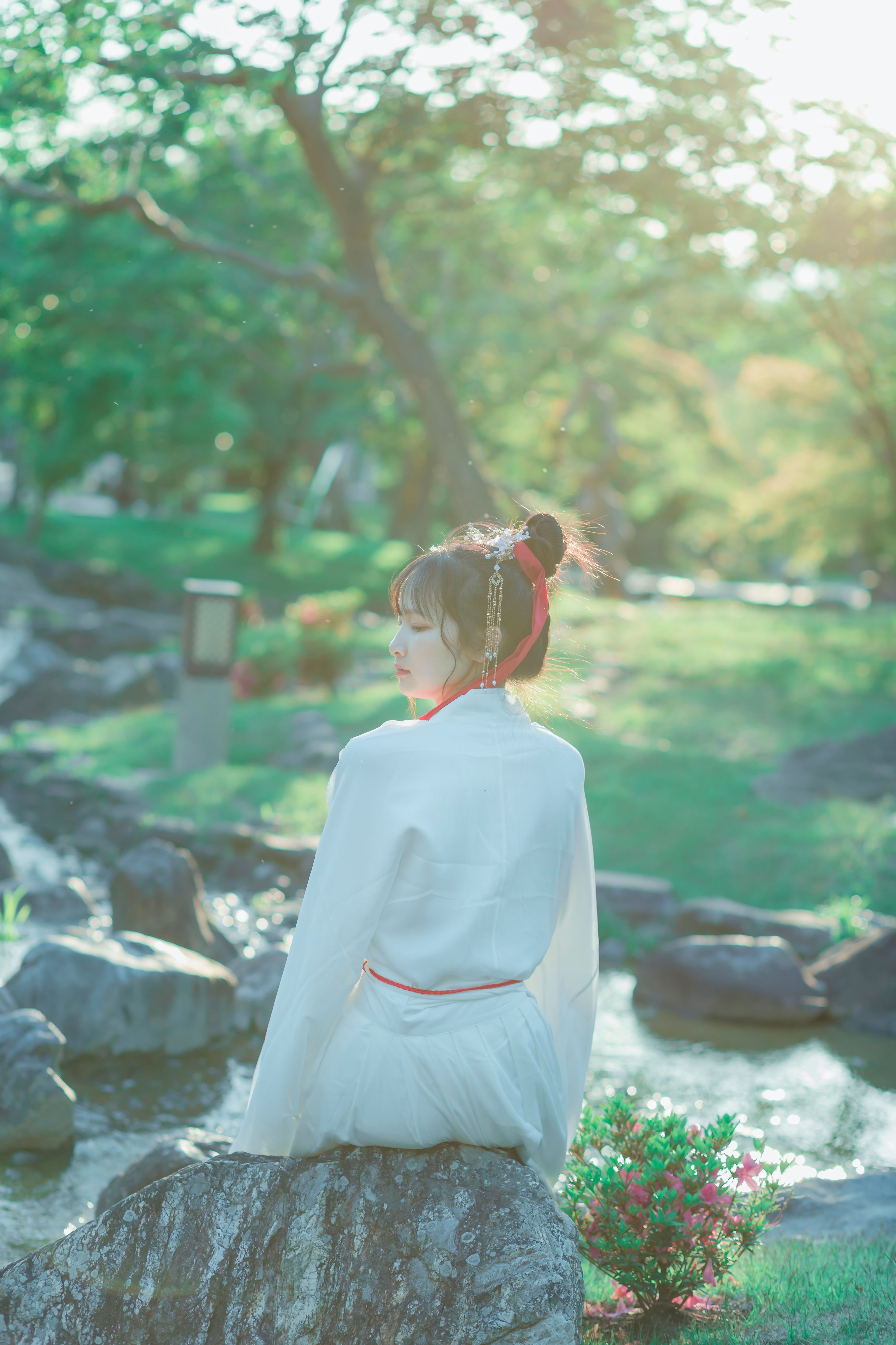 A Woman in White Long Sleeve Dress Sitting on the Rock · Free Stock Photo