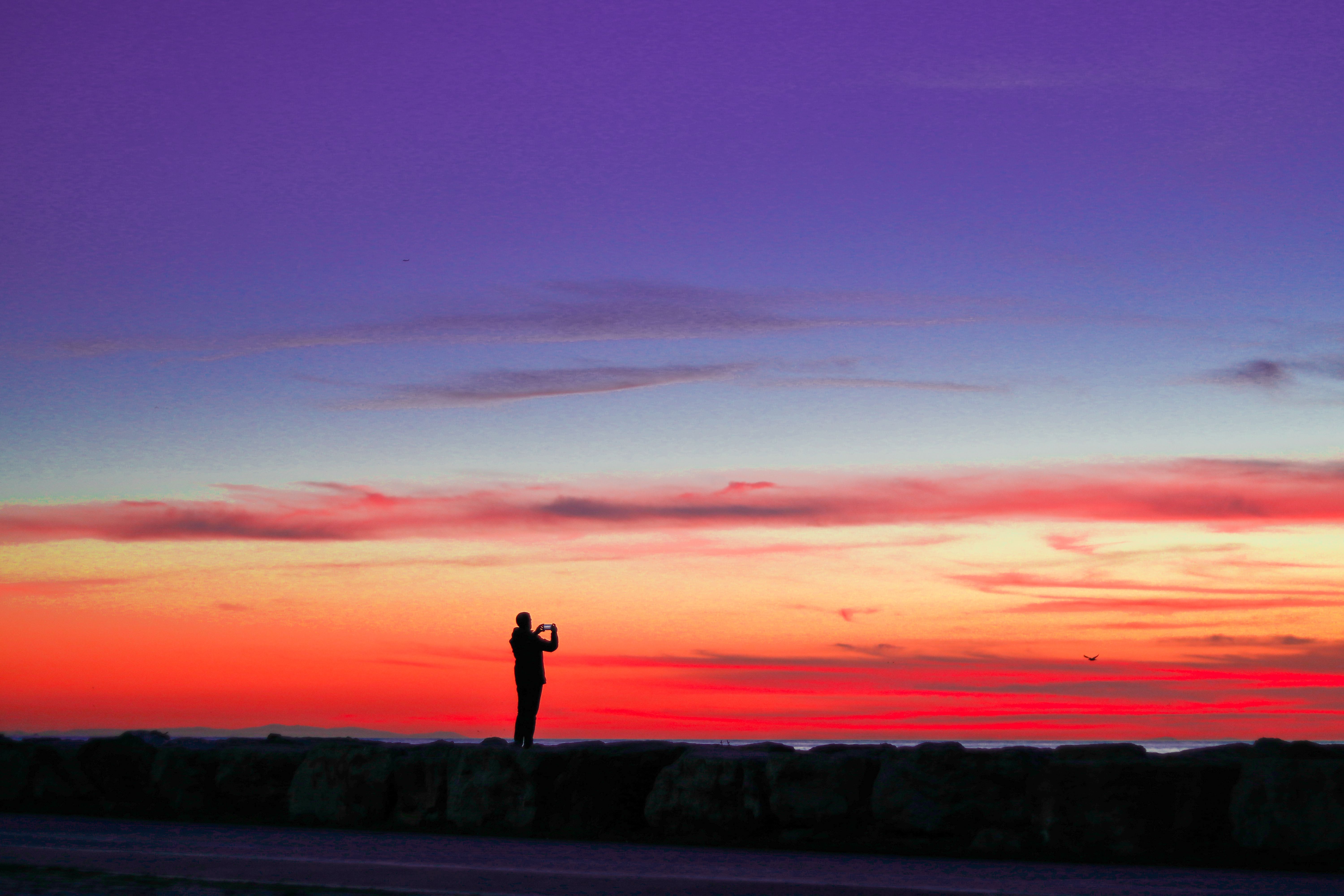 A striking silhouette of a photographer capturing a stunning sunset sky in İstanbul, Turkey.. striking, silhouette, photograp