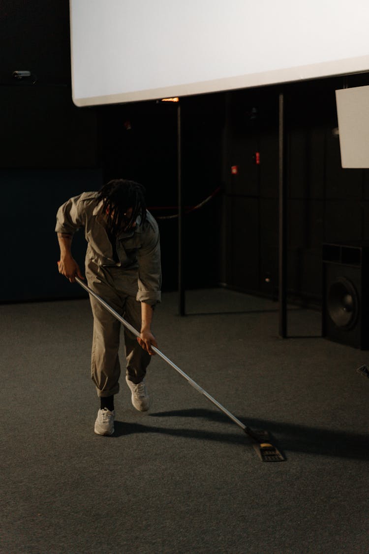 Man Wearing Uniform Cleaning The Floor