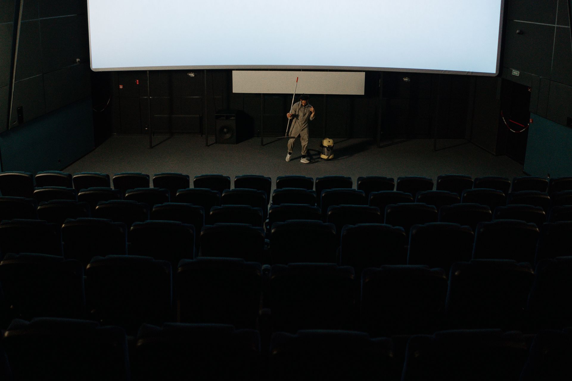 Man Cleaning Inside a Movie Theater