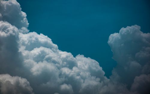 Free Puffy white cumulus clouds contrasting with a deep blue sky, creating a serene cloudscape. Stock Photo