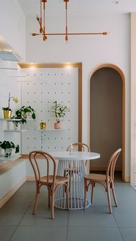 A chic, modern dining room with elegant design, featuring a round table and wooden chairs.