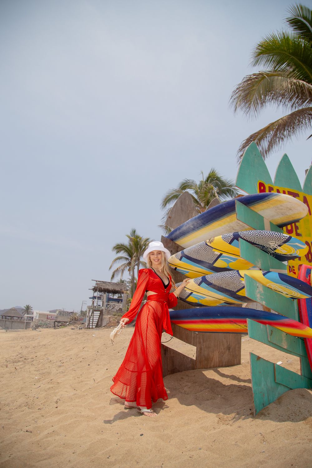 A Woman in Red Dress Standing Beside a Rack of Surfboards on the Beach ...