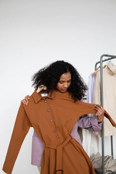 A Woman Holding a Brown Long Sleeve Dress