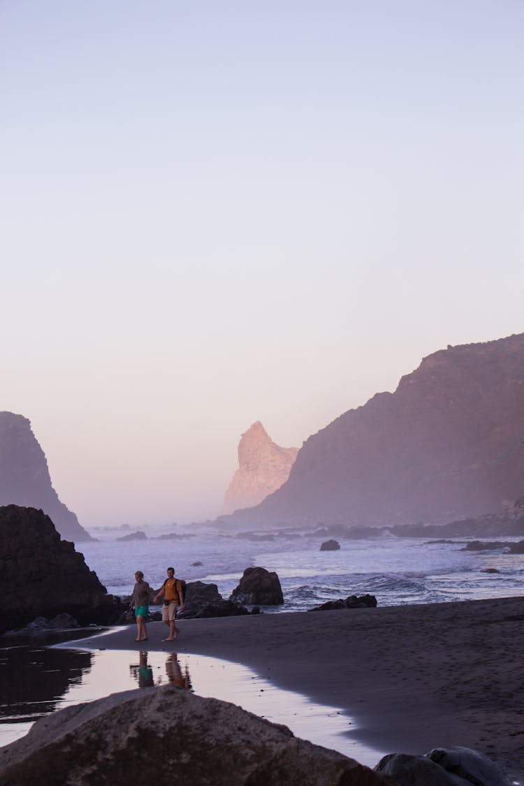 Couple Holding Hands Walking On Beach 