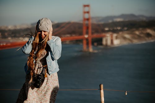 Free Woman Covering Her Ears while Standing Near Golden Gate Bridge Stock Photo