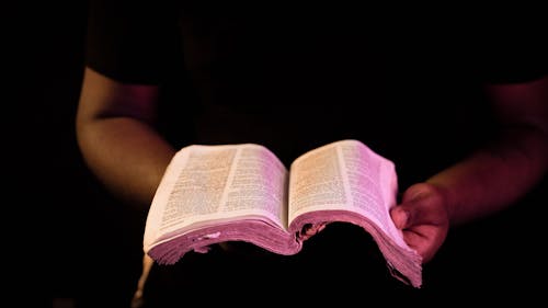 Free Person Holding Bible With Black Background Stock Photo