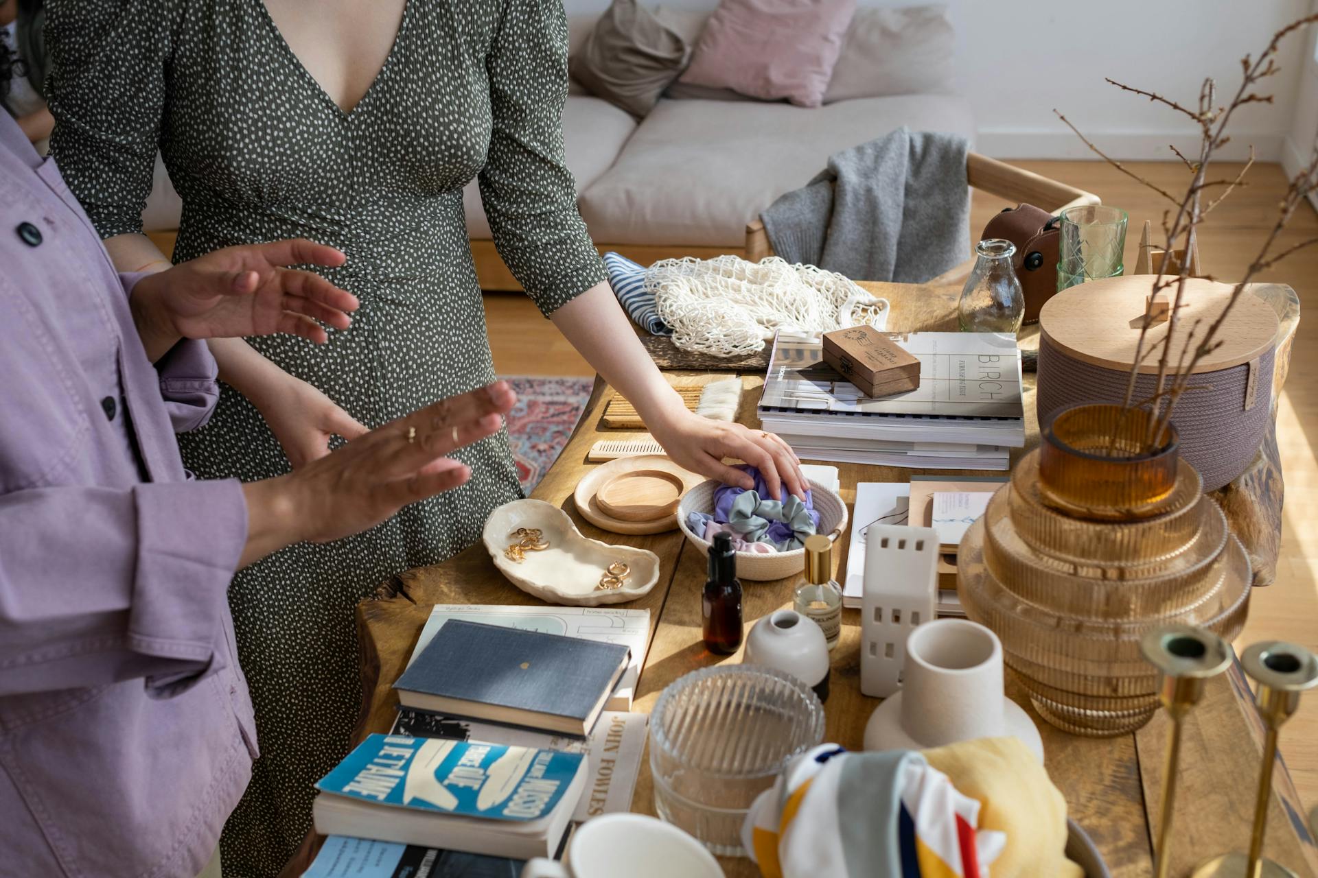 Two women exchanging books and trinkets indoors, emphasizing eco-friendly barter practices.