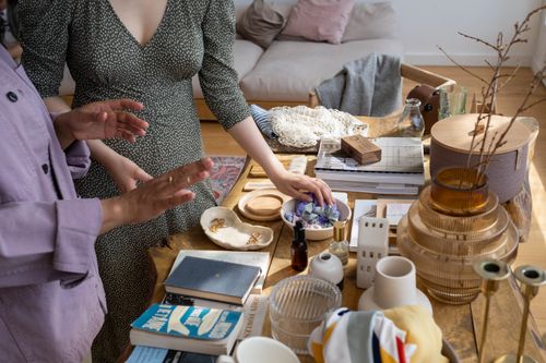 Free Two women exchanging books and trinkets indoors, emphasizing eco-friendly barter practices. Stock Photo