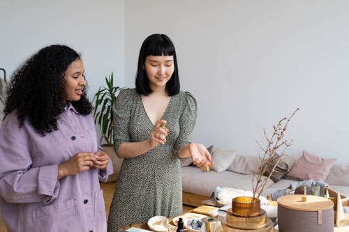 Two Women Standing Beside the Table