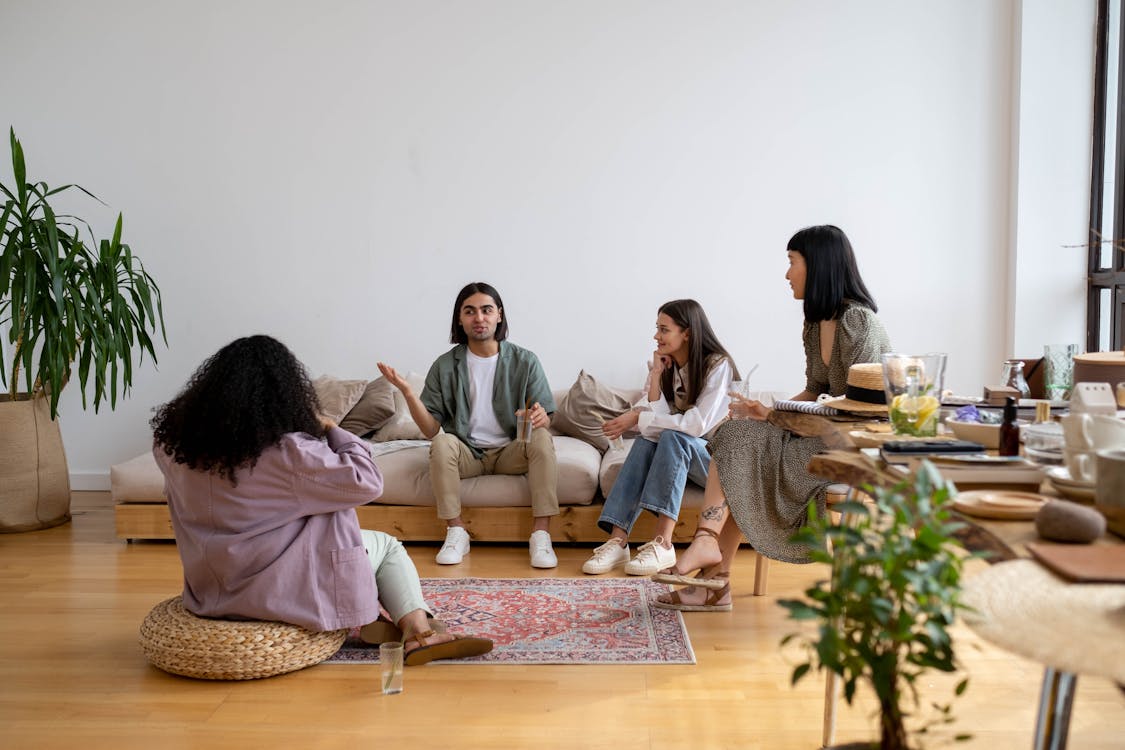 Free People Sitting on the Living Room Talking Stock Photo