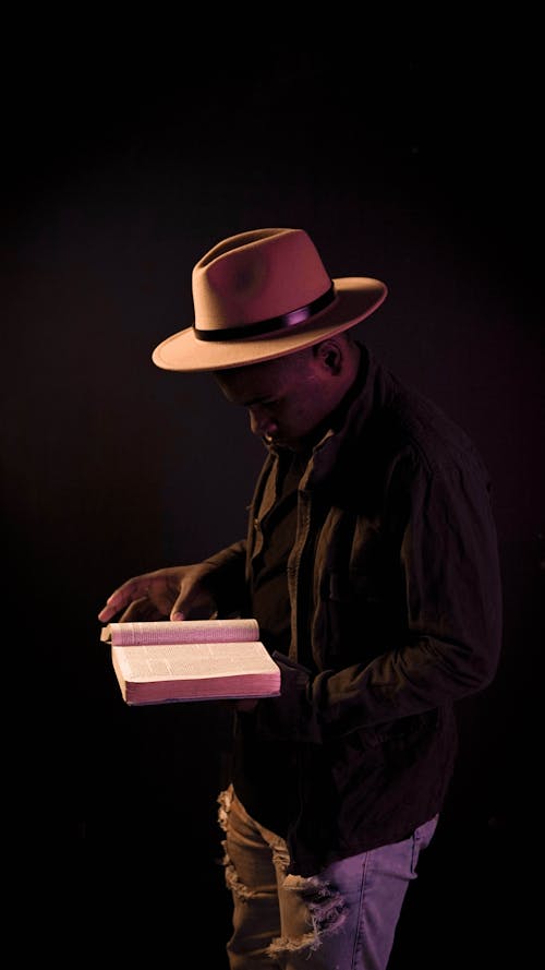 Free Man Wearing a Panama Hat while Reading a Book Stock Photo