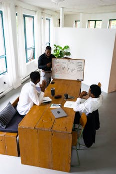 Professional team in a brainstorming session around a table in a bright office space.