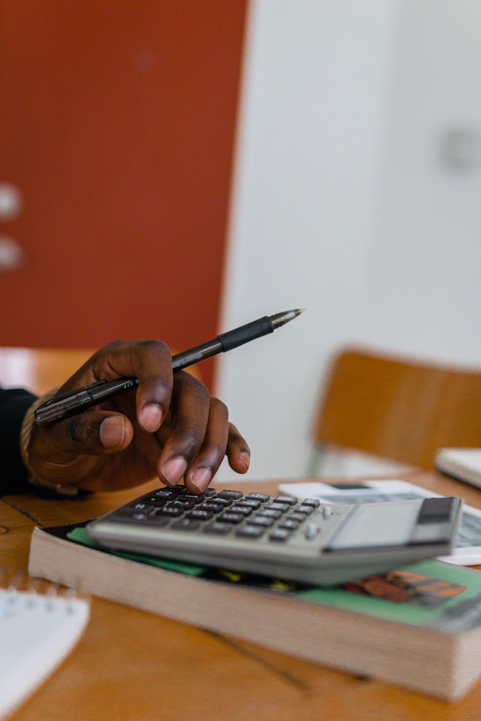 A hand running the numbers — the few figures that actually run the business