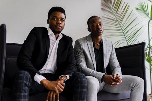 Men Wearing Suits Sitting on a Couch
