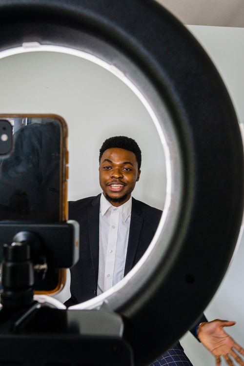 Free Young African American man communicates via smartphone with professional lighting. Stock Photo