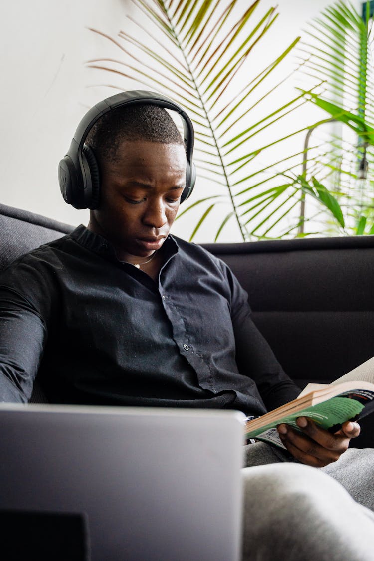 Photo Of A Man With Black Headphones Reading A Book