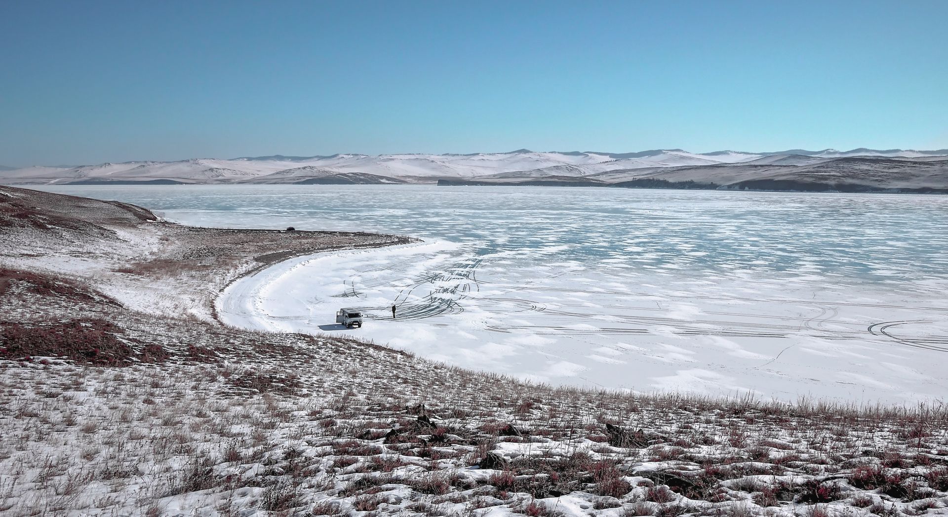 A vast frozen lake in Russia with a rugged snow-covered landscape. Perfect for winter adventures.