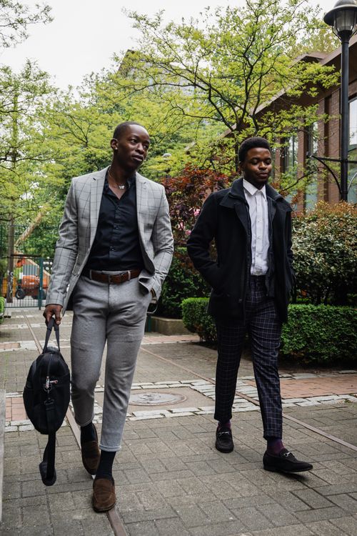 Free Two well-dressed men walk through a modern urban environment showcasing contemporary fashion. Stock Photo