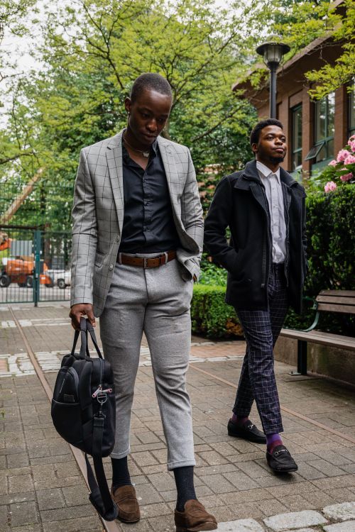 Free Two fashionable men walking confidently in a city park, showcasing modern styles. Stock Photo