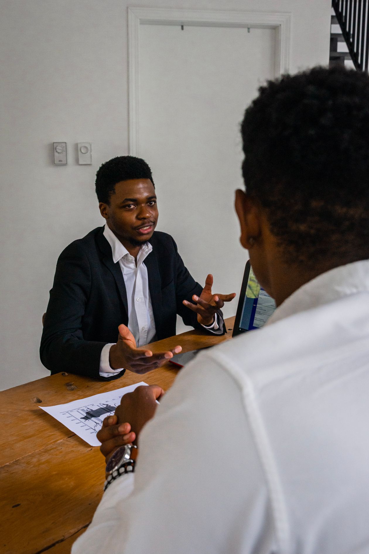 Two African tech professionals discussing security work at a desk