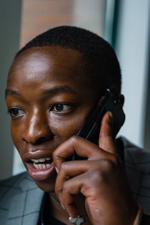 Free Close-up of man in suit talking on a smartphone indoors. Stock Photo