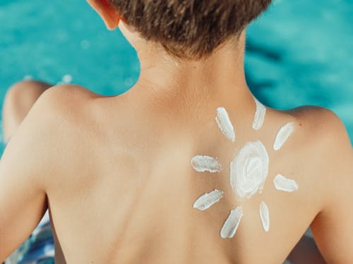 Free Sun Drawing Sunscreen on Child s Back Photo Stock Photo
