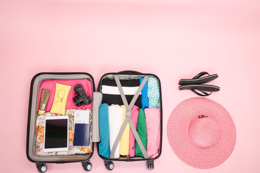 Open suitcase packed neatly with clothes and travel essentials, perfect for a summer getaway.