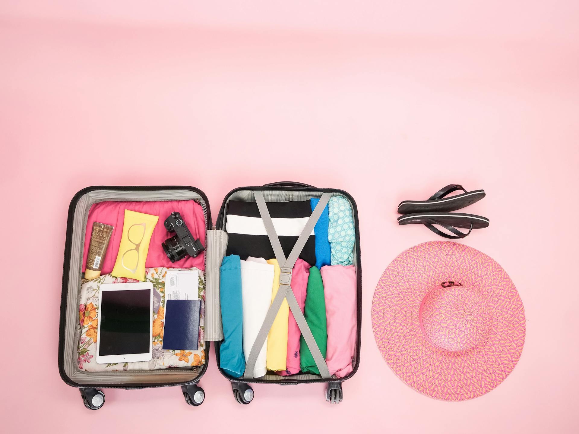 Open suitcase packed neatly with clothes and travel essentials, perfect for a summer getaway.