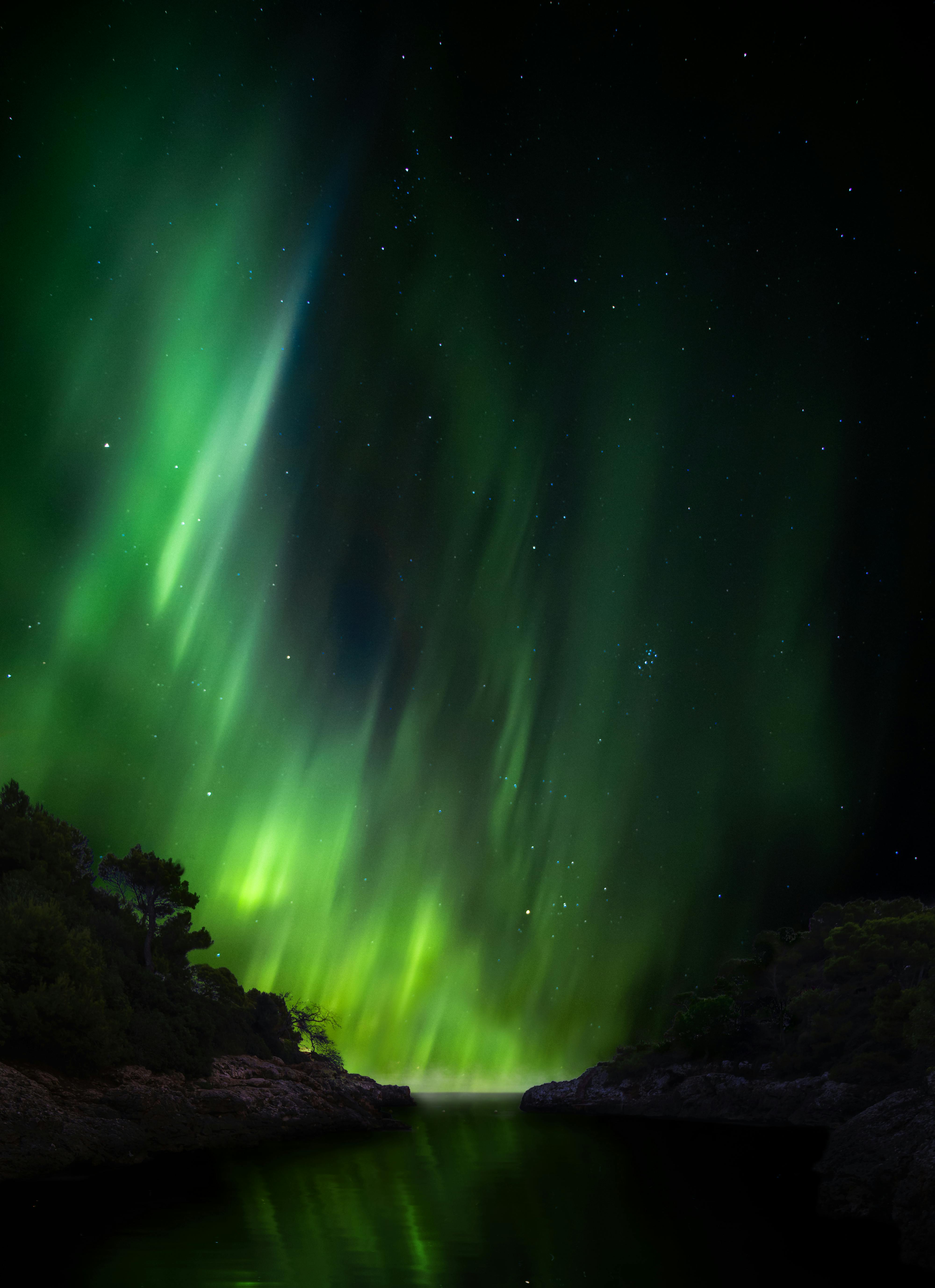 Mesmerizing northern lights illuminate the night sky over a serene Swedish landscape.