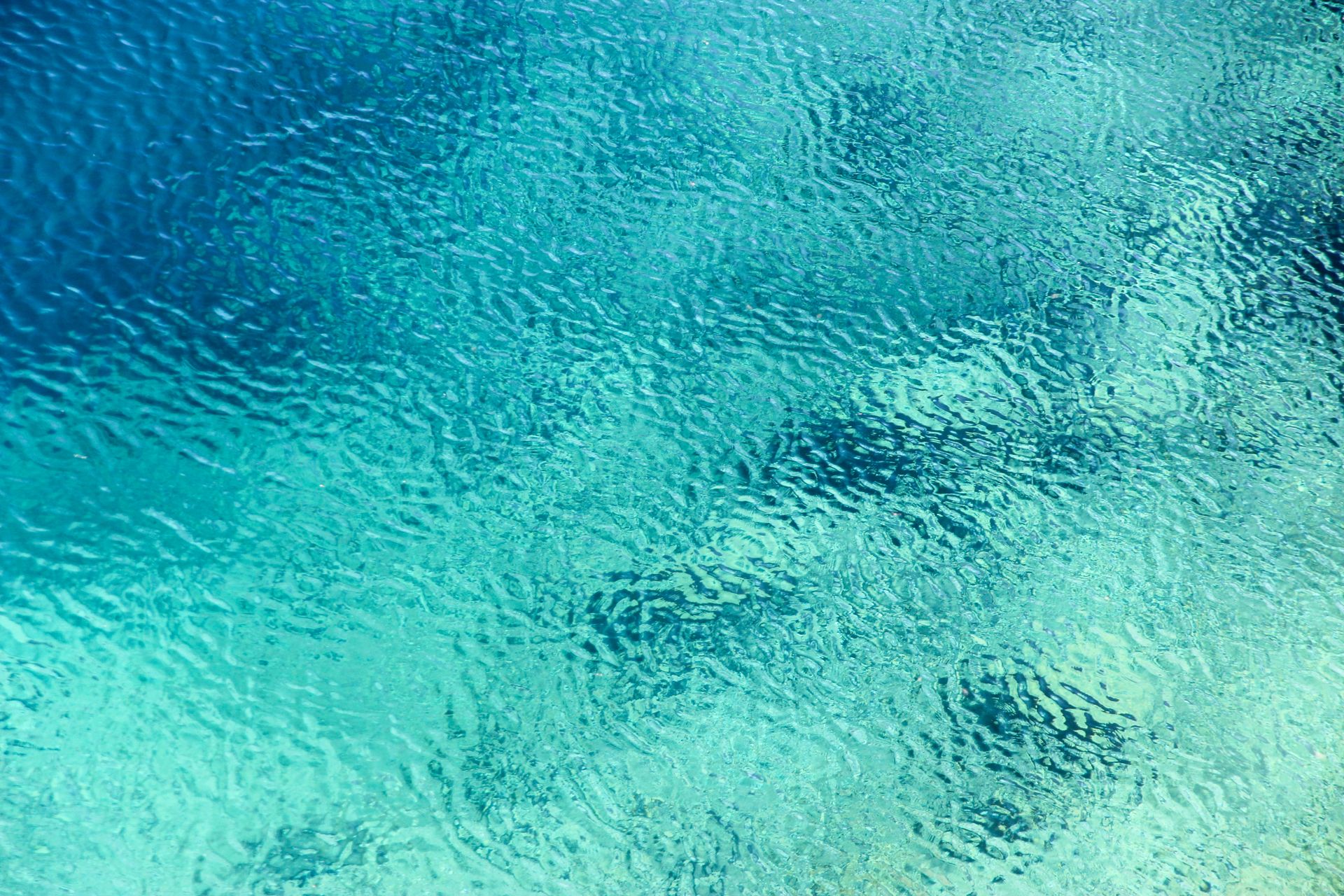 Aerial view of turquoise ocean water surface with gentle ripples